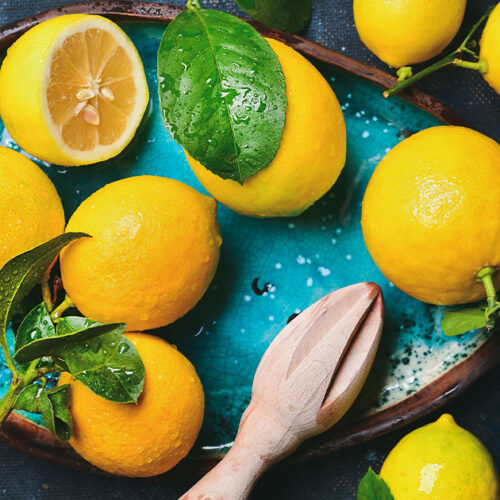 Fresh lemons on blue tray.