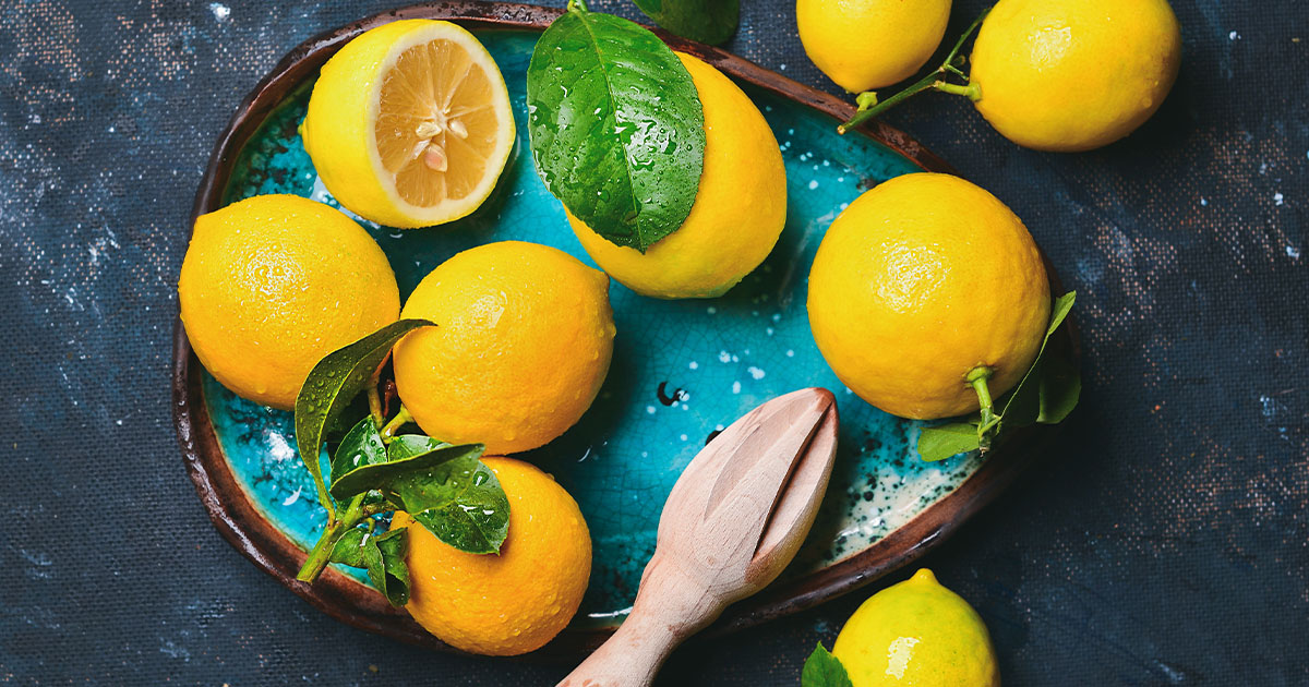 Fresh lemons on blue tray.