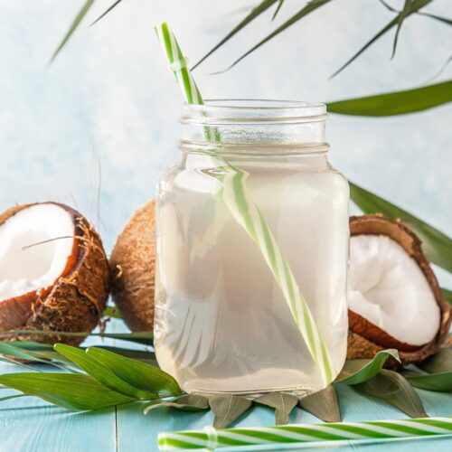 Coconut water in glass with straw.