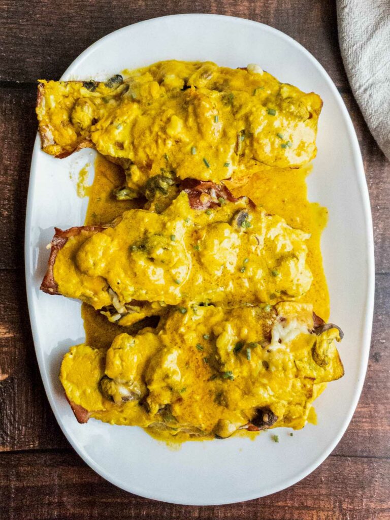 baked cheesy chicken with mustard sauce on white plate