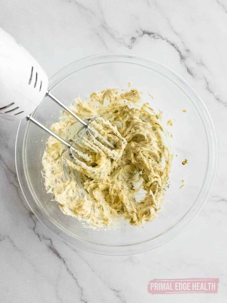 Mixing the rosemary compound butter in a glass bowl.