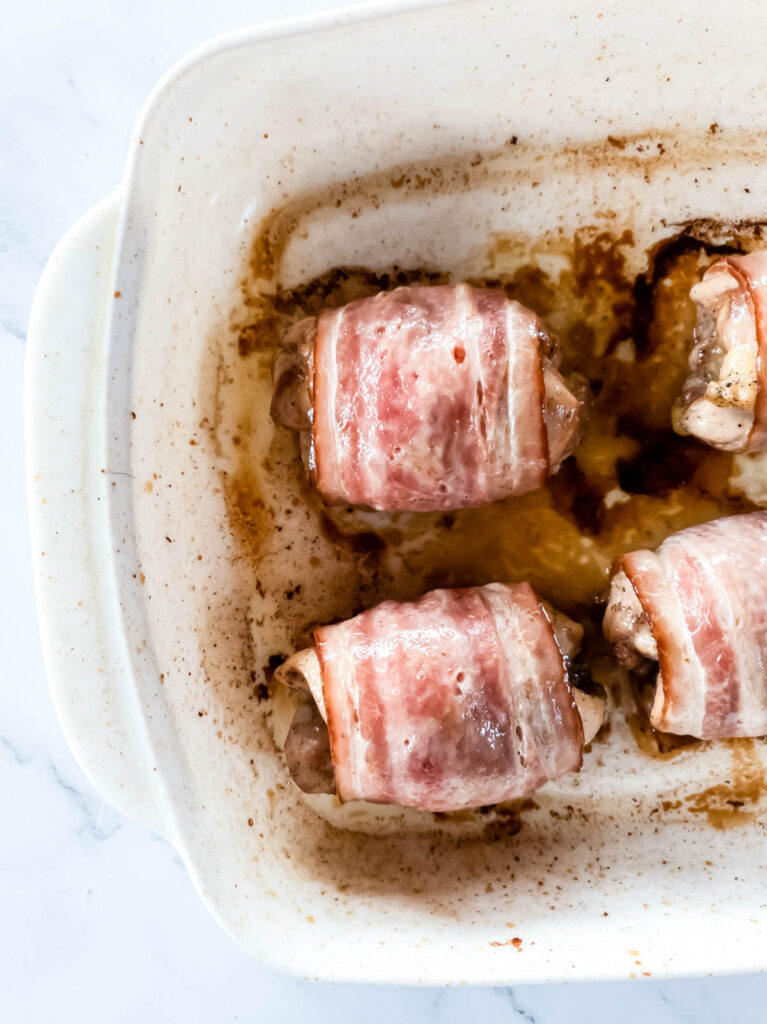 Bacon wrapped chicken thighs coming out of oven.