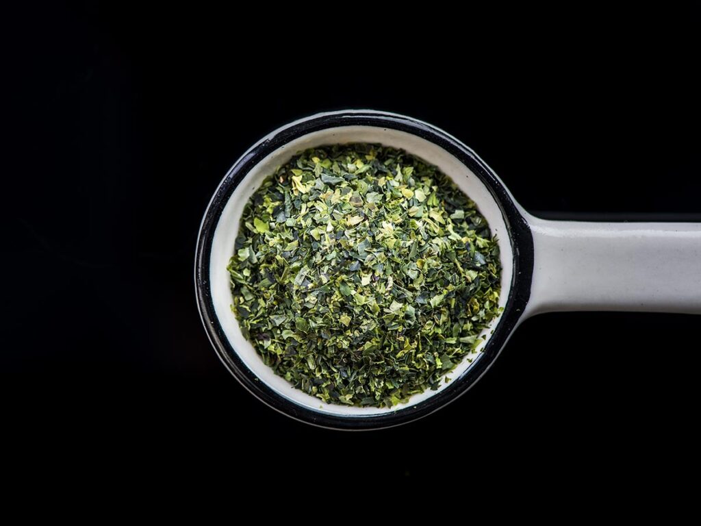 Seaweed flakes in measuring spoon.