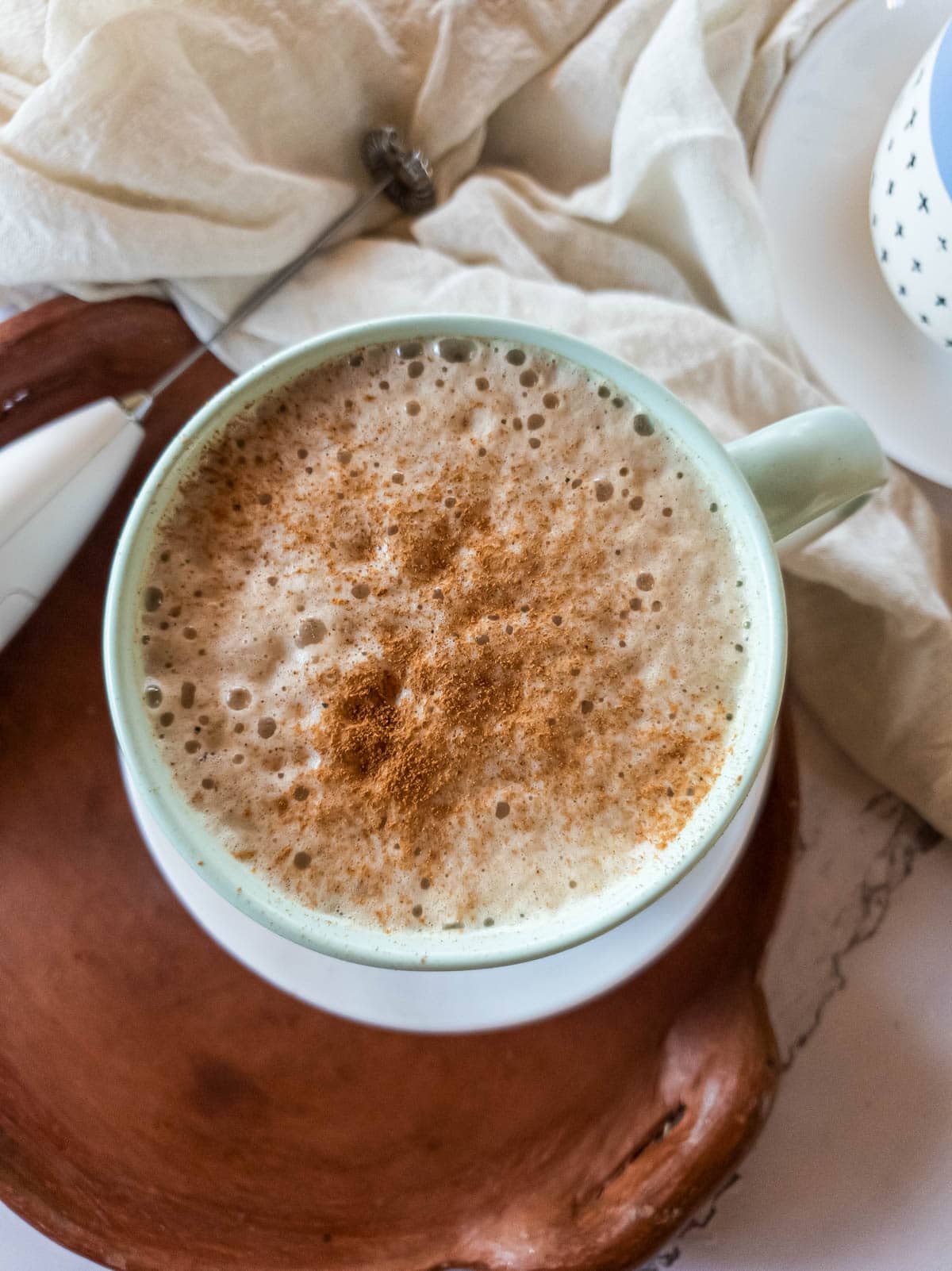 Adaptogenic latte with ashwagandha and cinnamon on clay tray.