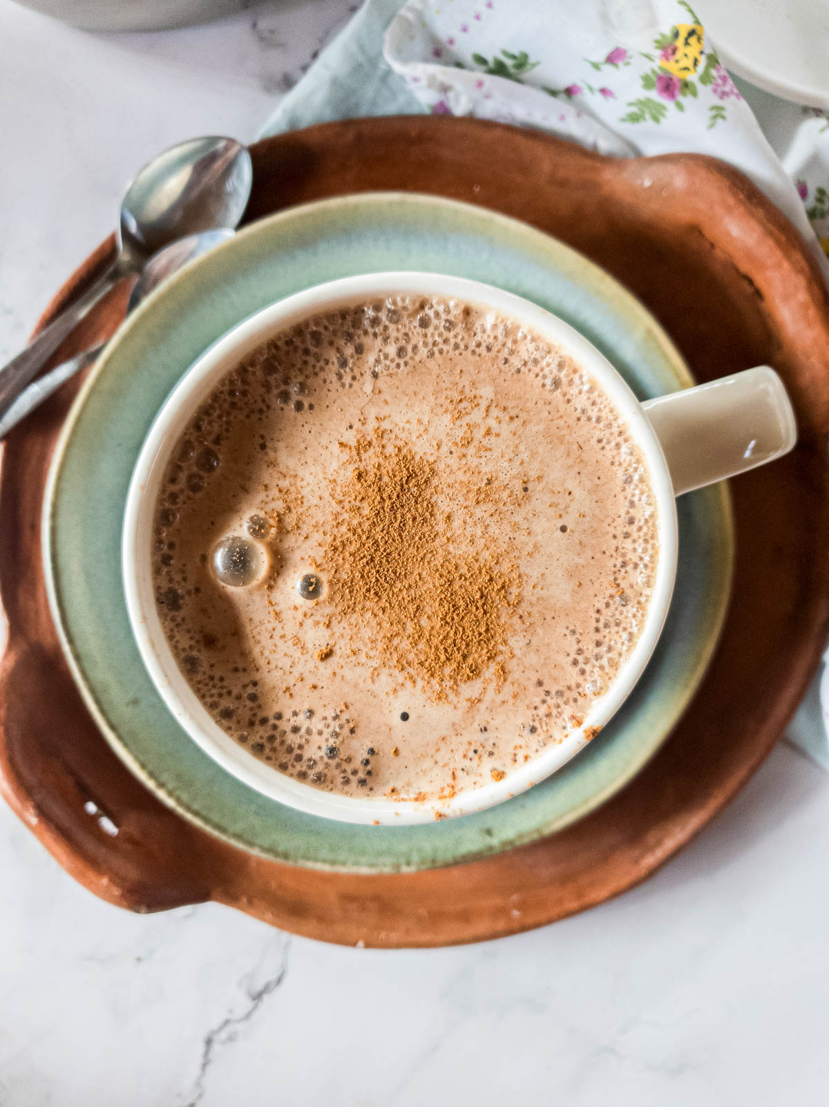 A picture of bone broth latte in large mug with blue plate and serving tray.