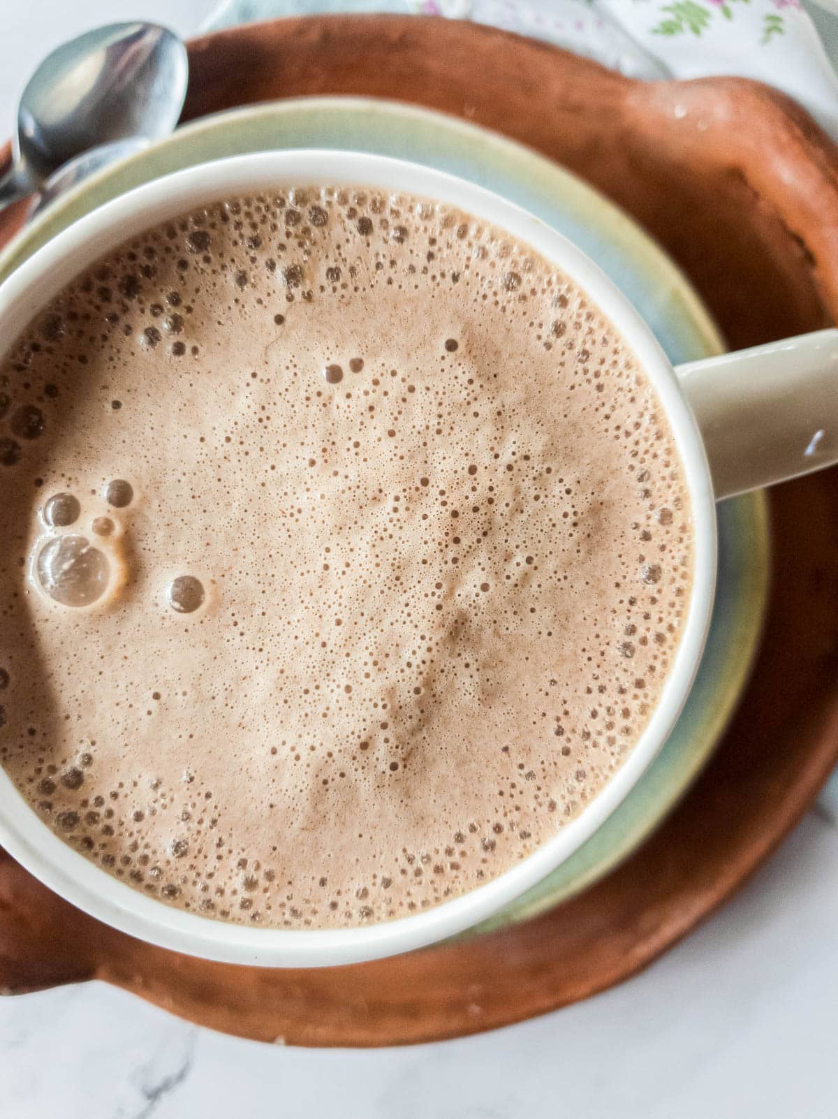 Close up picture of broth latte with frothed milk and bubbles.