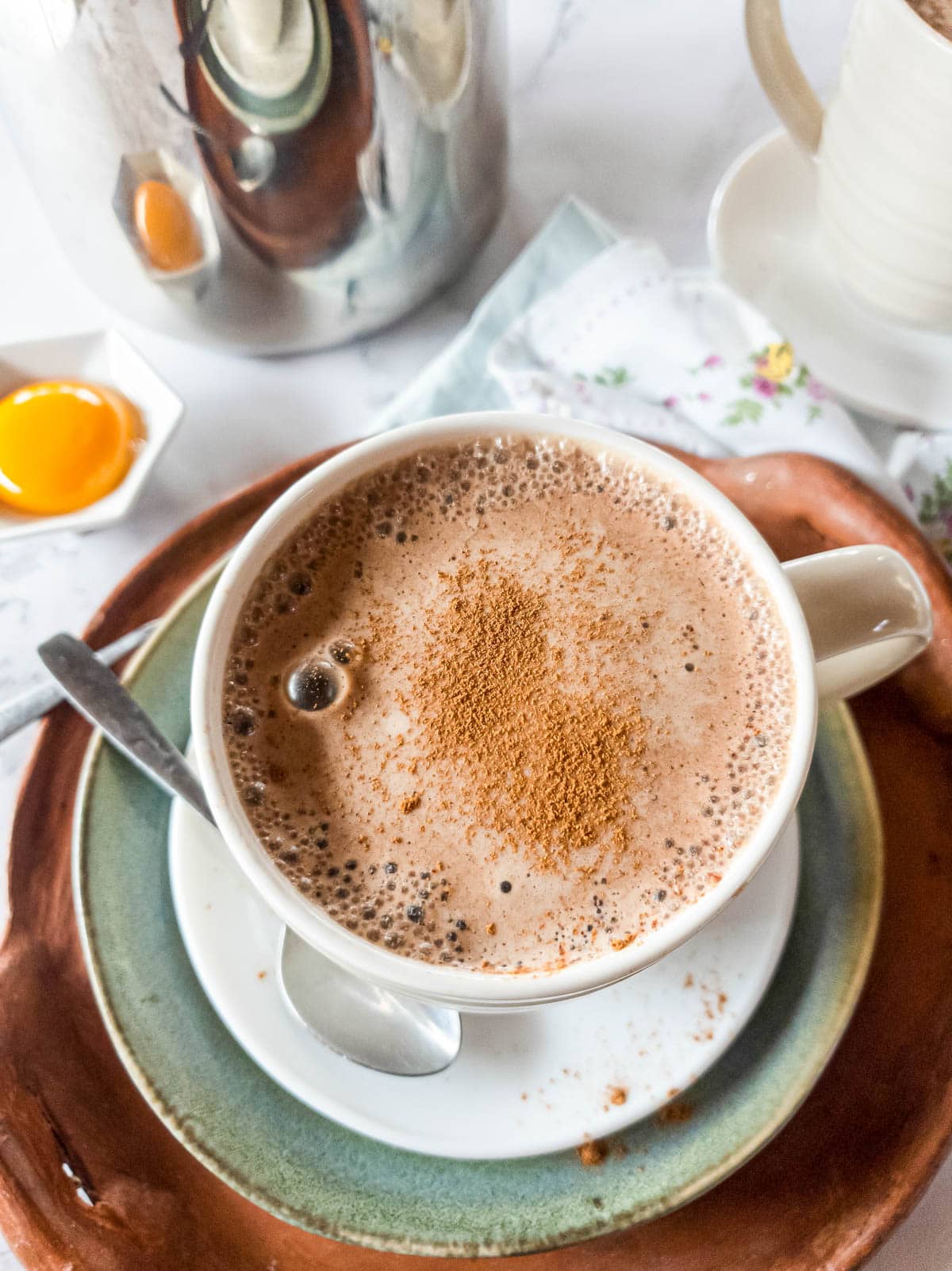 A picture of bone broth latte with French press in background.