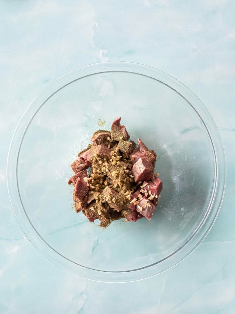 Bowl of beef heart in herbs and spices.