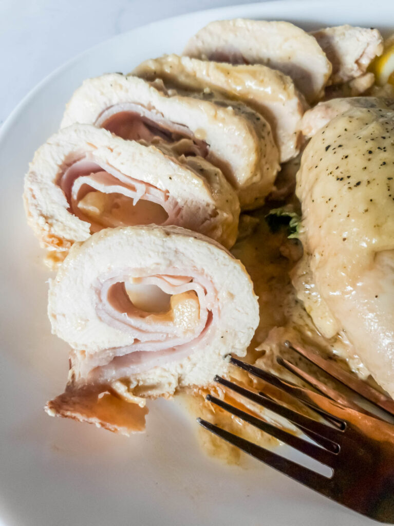 A picture of chicken breast rolled with ham and Swiss cheese cut into slices.