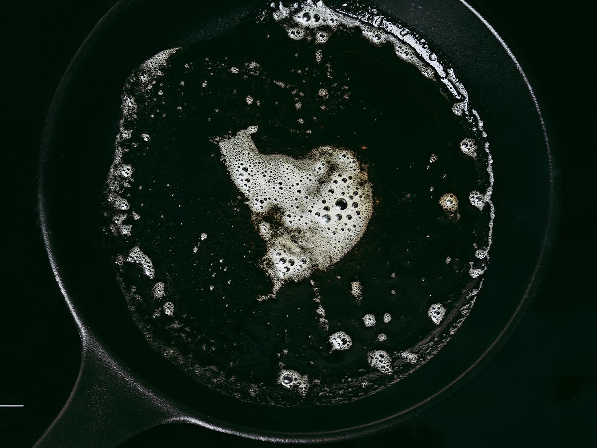 A cast iron pan with a soapy water on it.