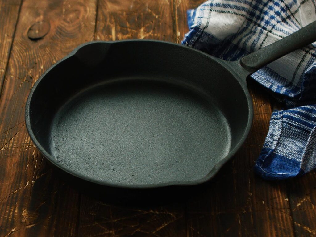 A cast iron frying pan on a wooden table.