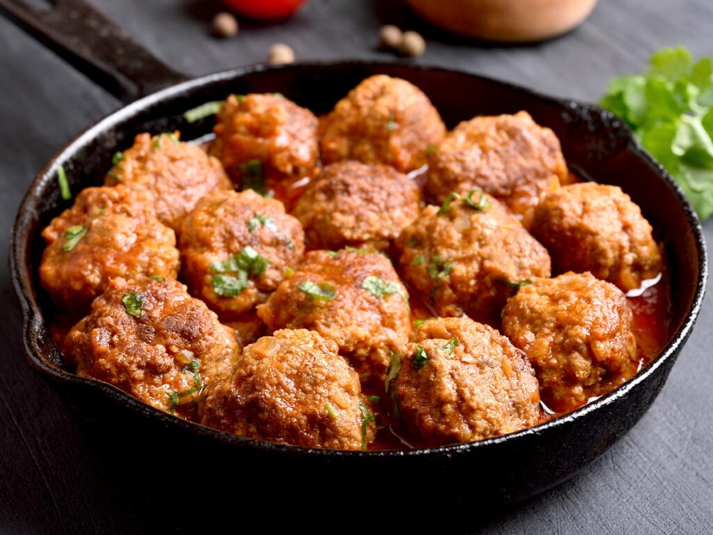 Meatballs in tomato sauce in a skillet.