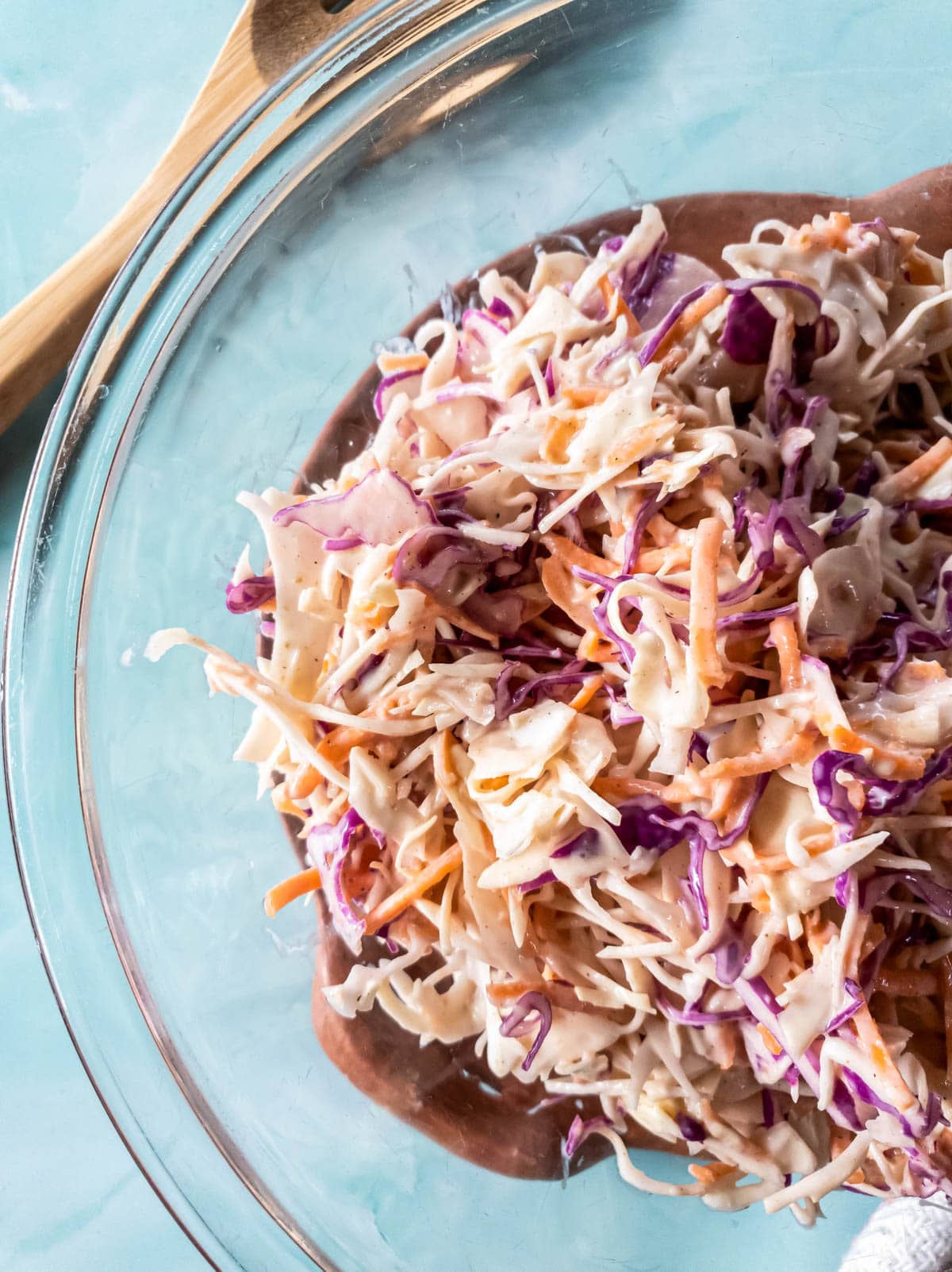 A picture of sugar-free coleslaw in glass bowl on blue background.