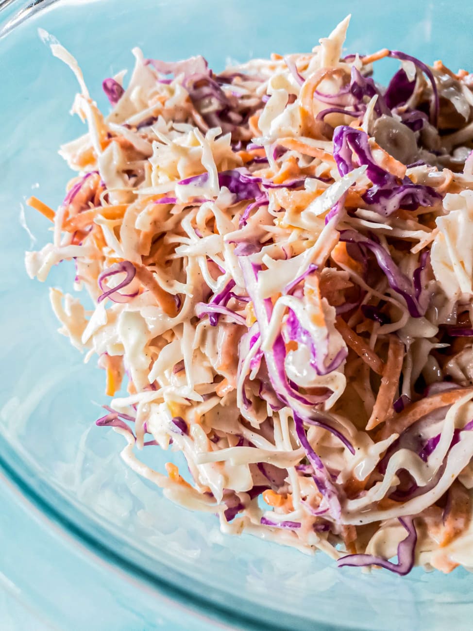 A picture of cabbage mix with creamy dressing in glass bowl.