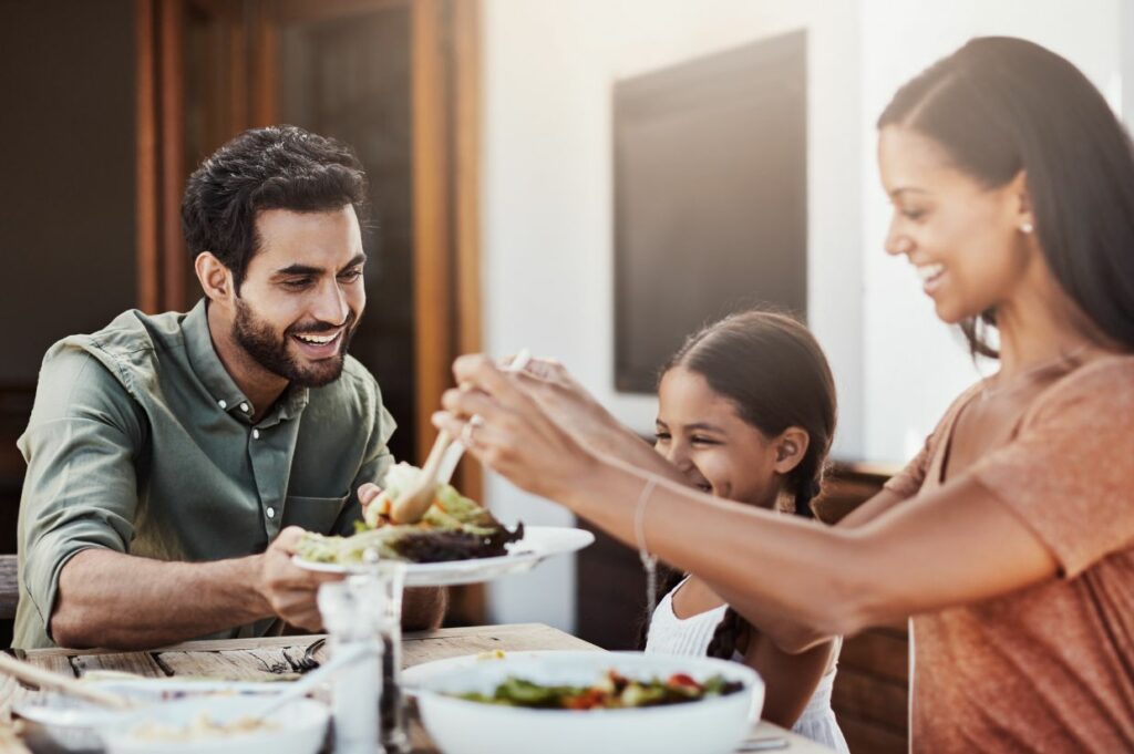 A family with food allergies is eating dinner together at a table.