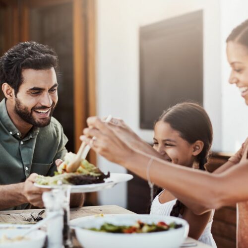 A family with food allergies is eating dinner together at a table.