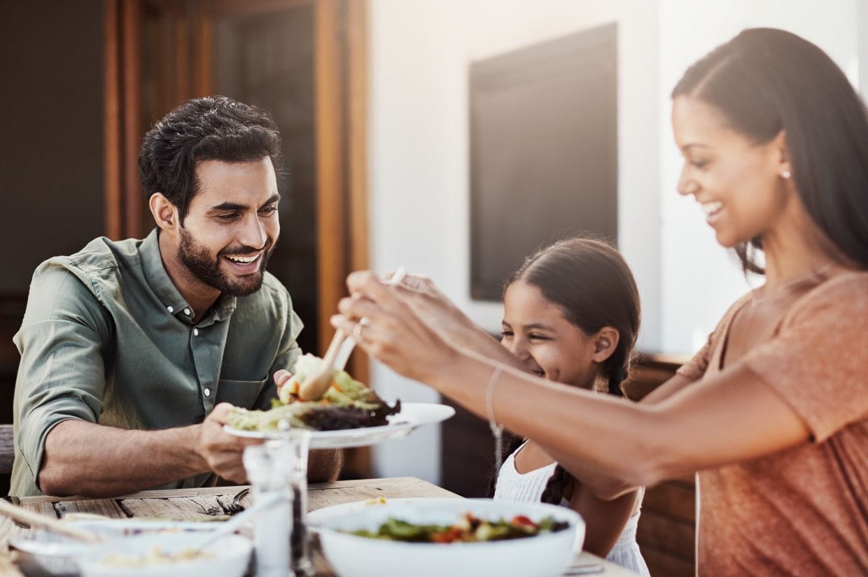 A family is eating dinner together at a table.