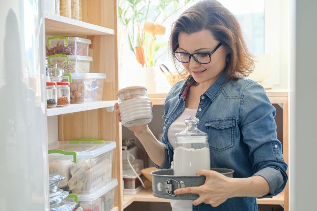 A woman is sorting out her pantry goods.