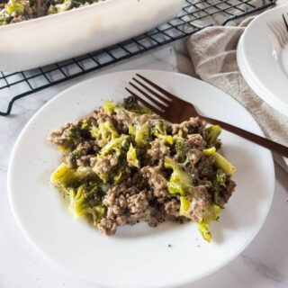 Ground hamburger meat and broccoli casserole on a plate with a fork.