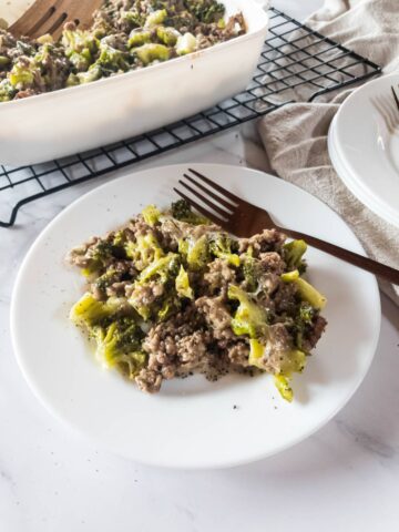 Ground hamburger meat and broccoli casserole on a plate with a fork.