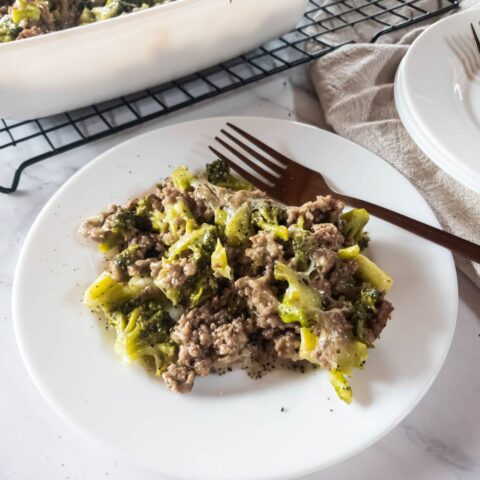 Ground hamburger meat and broccoli casserole on a plate with a fork.