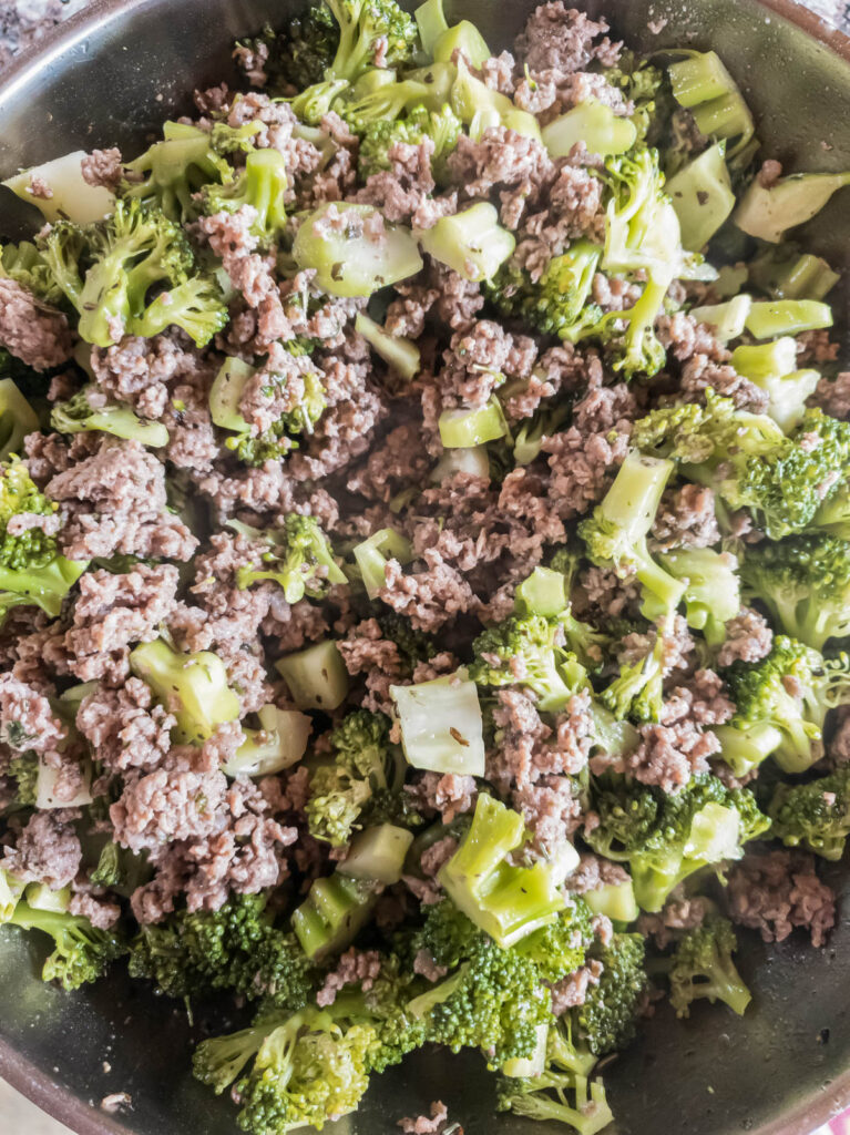 A pan with broccoli and meat in it.
