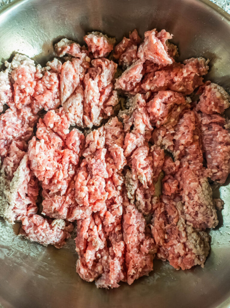 Ground beef in a skillet, cooking over stovetop.
