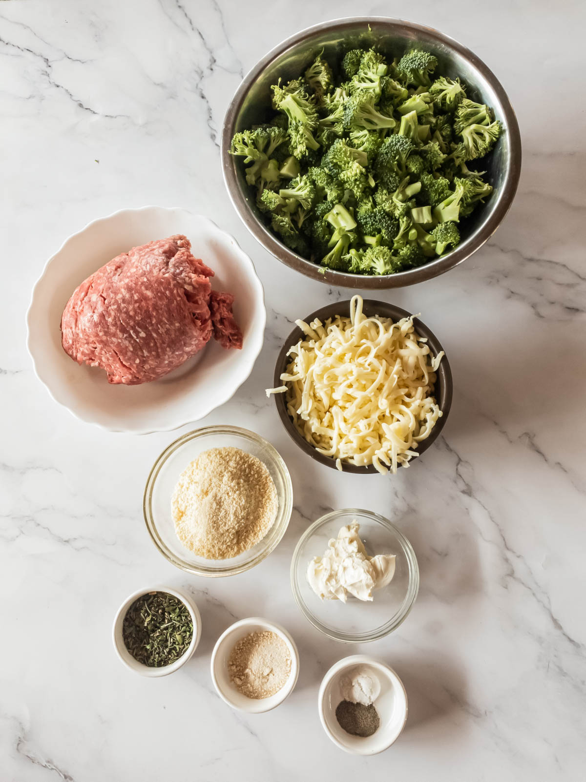 Ingredients for hamburger broccoli casserole on a marble countertop.