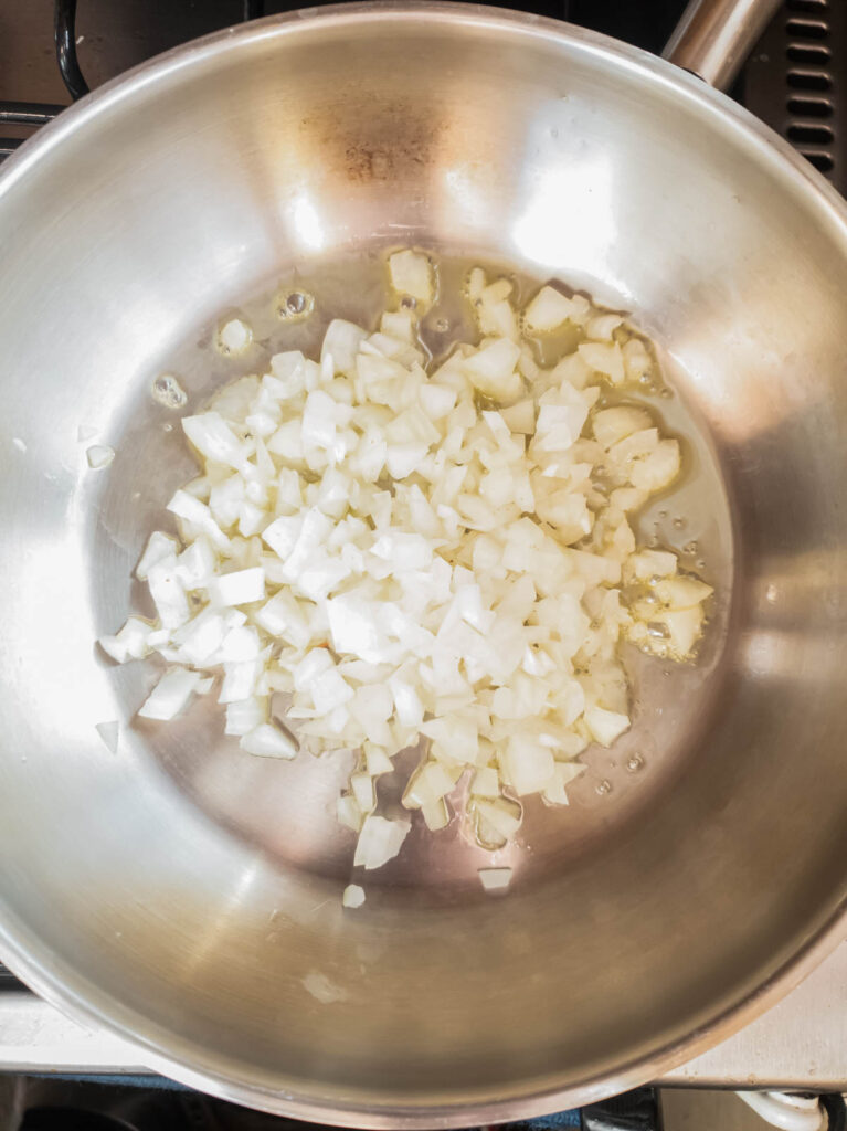 Onions sizzling in a pan, perfect for a keto meat pie.