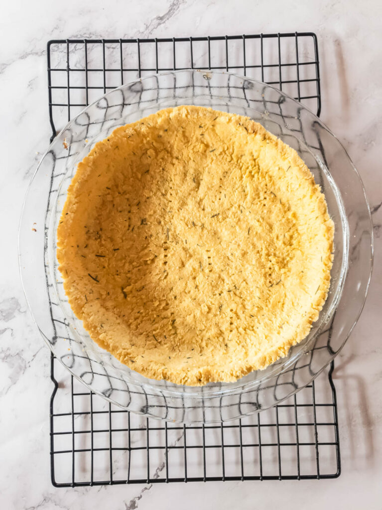 A savory coconut flour pie crust cooling on a rack.