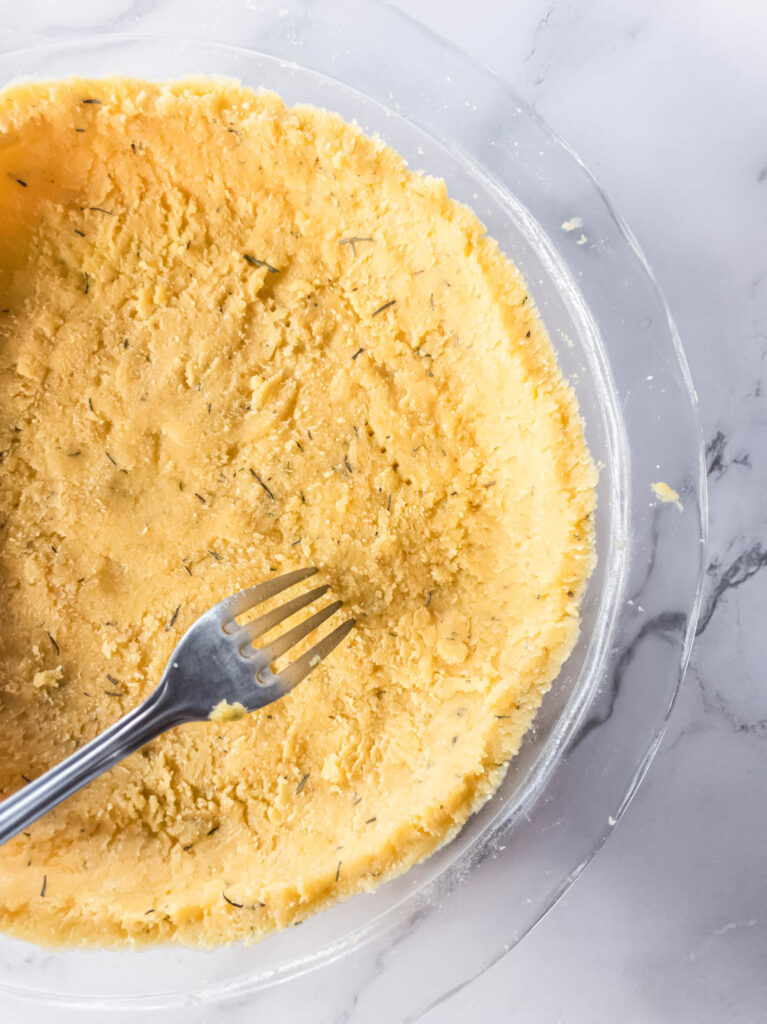 A silver fork pricking the crust before baking.