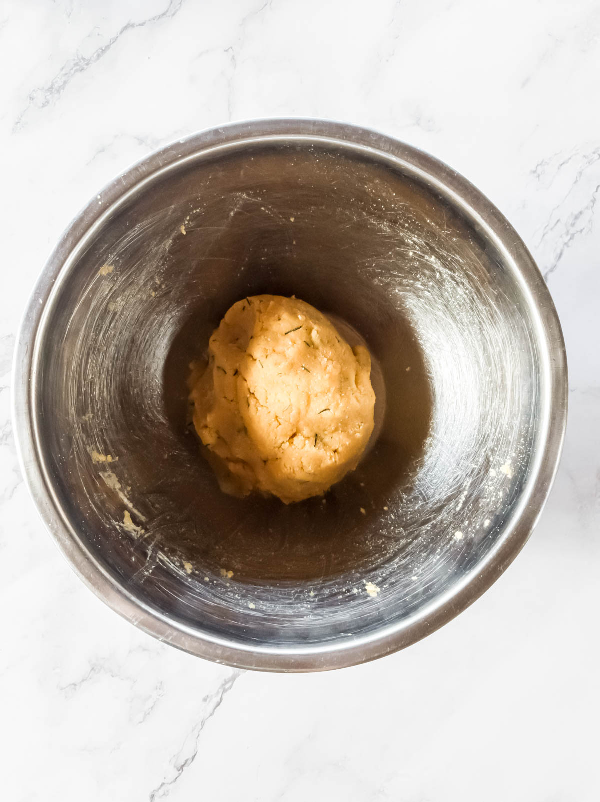 A round ball of dough in mixing bowl.