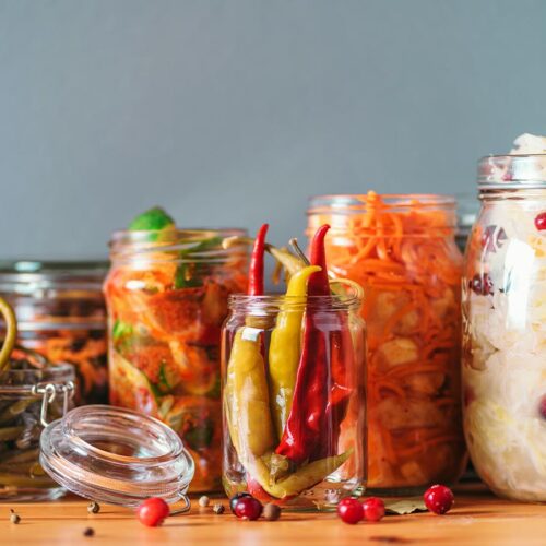 Jars of fermenting vegetables on a table.