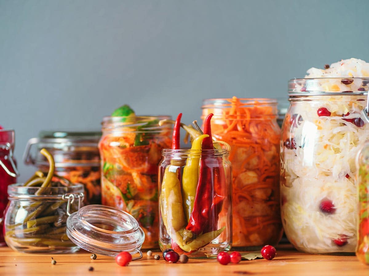 Jars of fermenting vegetables on a table.