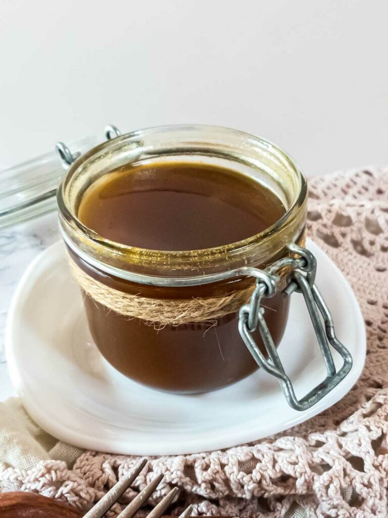 A jar of sugar-free pumpkin spice syrup on a white plate.