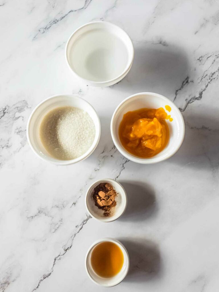 Five bowls of ingredients on a marble background.