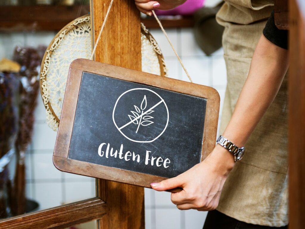 A woman holding a sign that says gluten free.