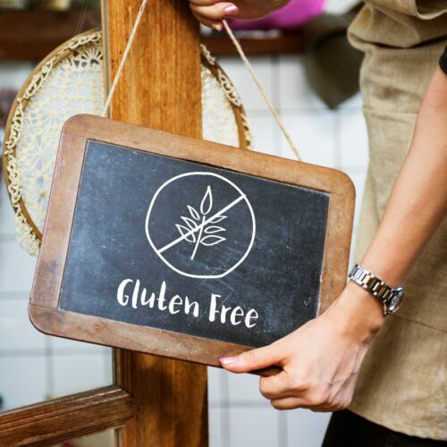 A woman holding a sign that says gluten free.