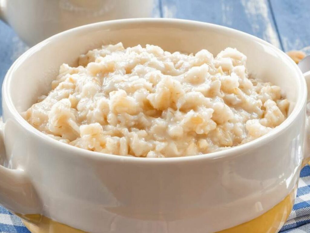 Oatmeal in a white bowl on a blue tablecloth.