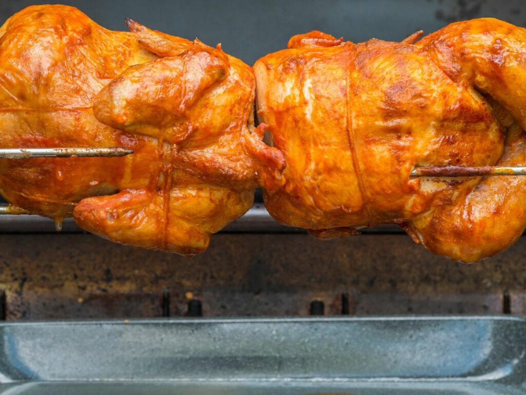 Two chickens on a rotisserie.