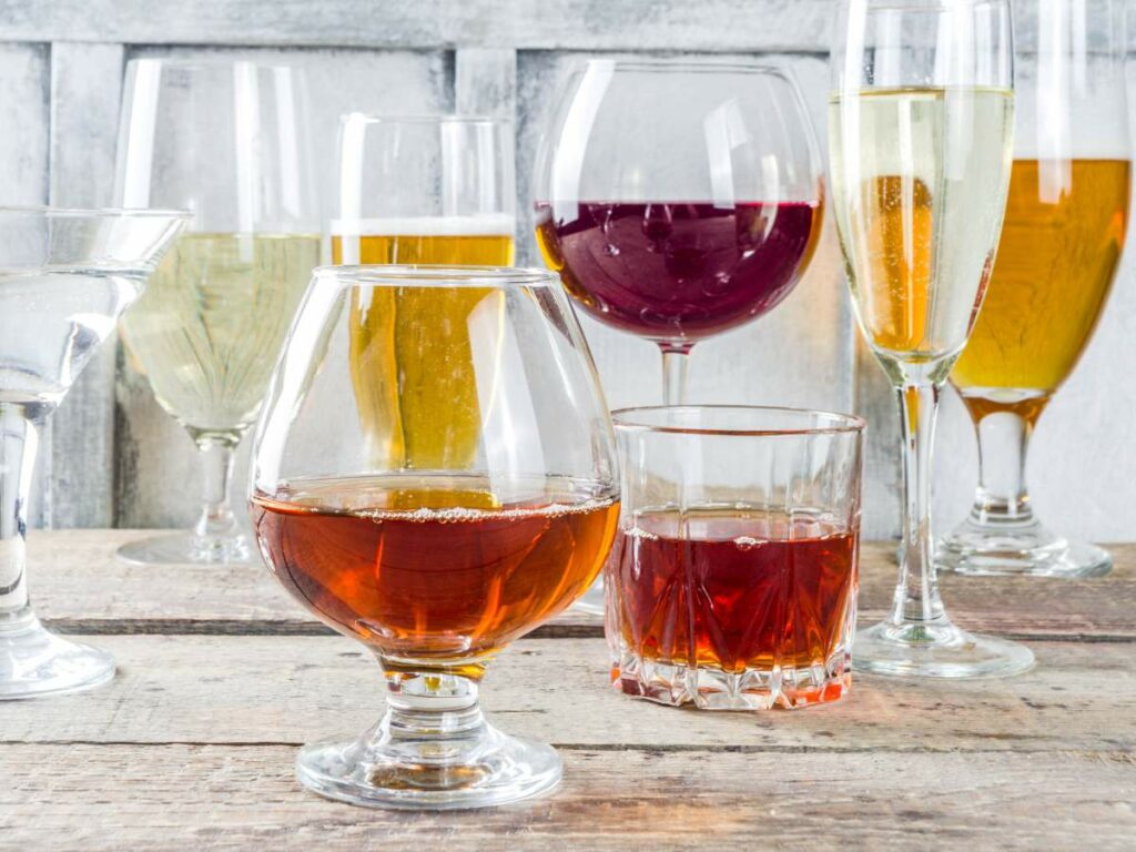 A group of glasses filled with different types of alcohol.