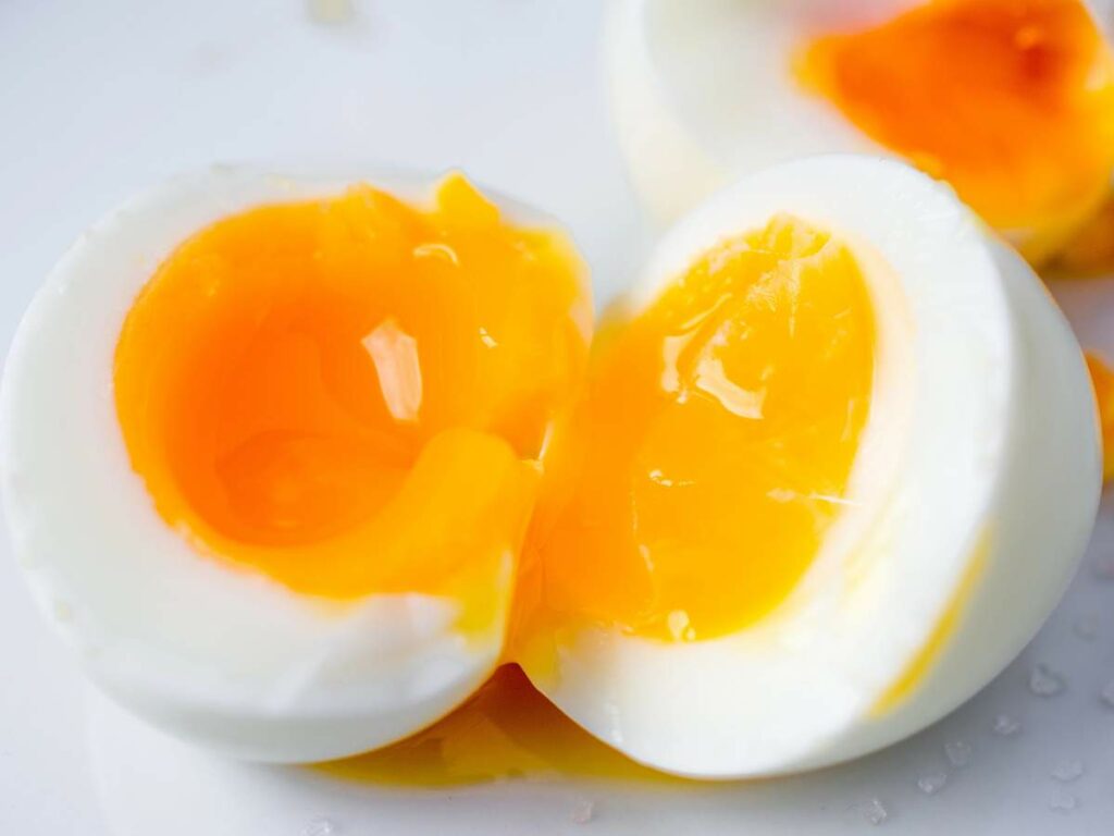 A soft-boiled egg cut in half, revealing a runny yolk.