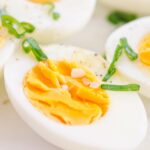 A close-up image of hard boiled eggs sliced open in half.