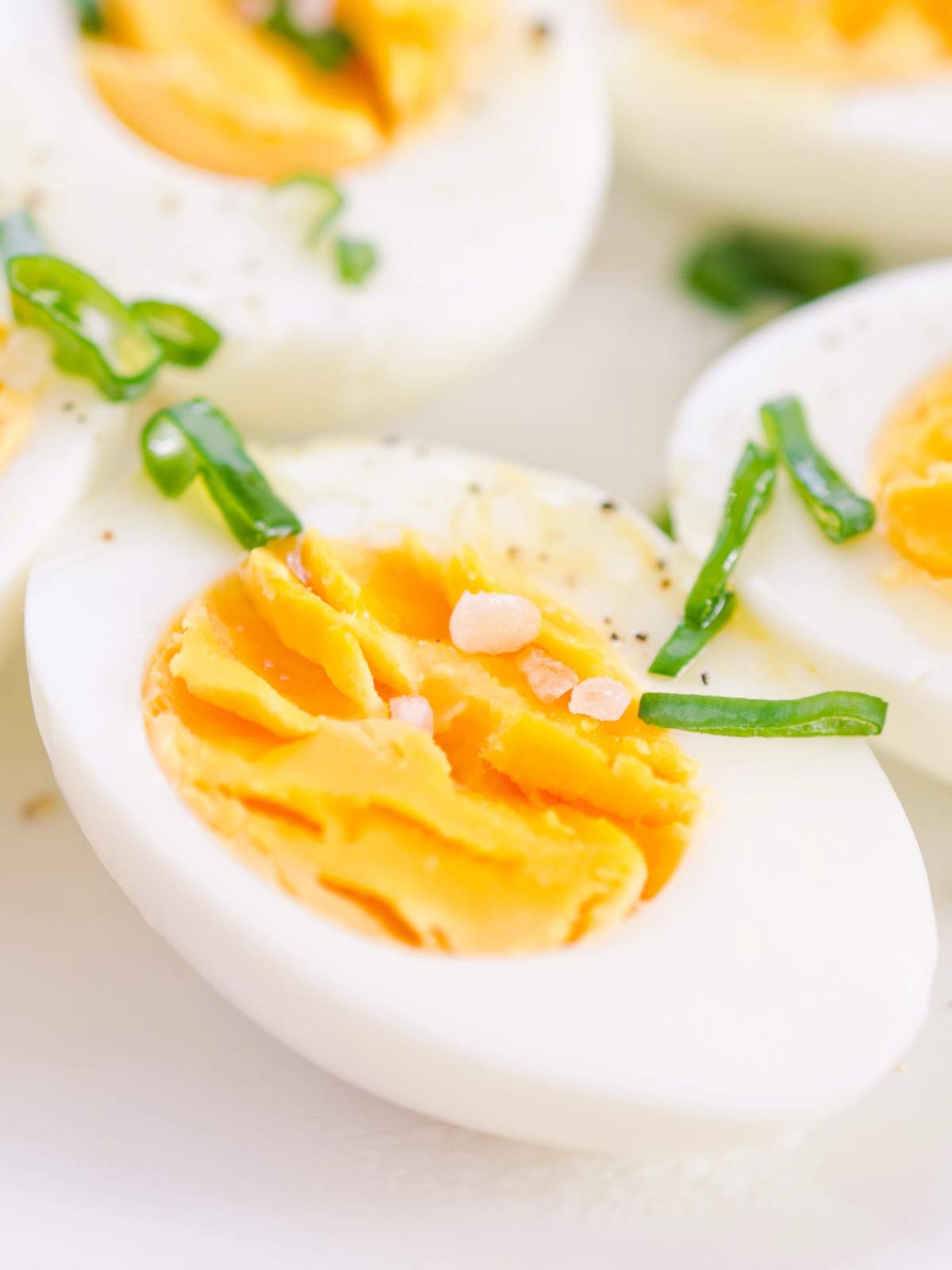 A close-up image of hard boiled eggs sliced open in half.