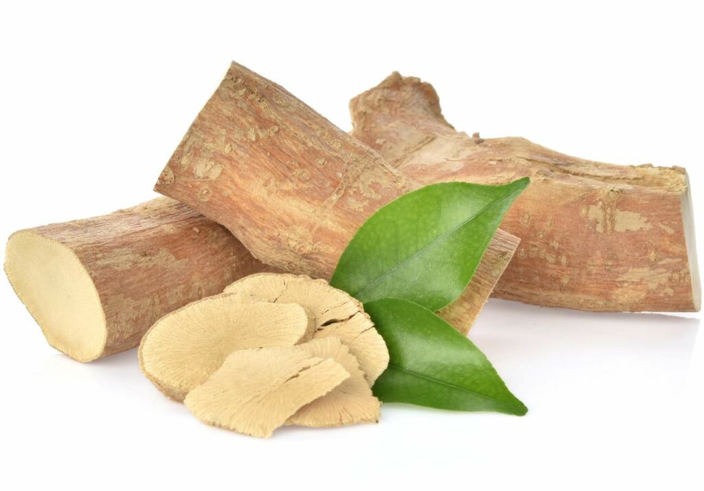 Fresh root slices with green leaf and thin cross-sections of the herb isolated on a white background.