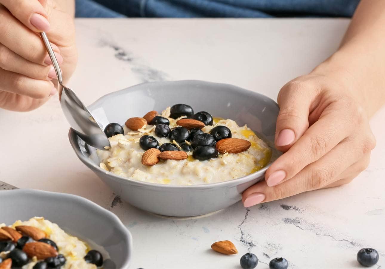 A bowl of oatmeal with blueberries and almonds.