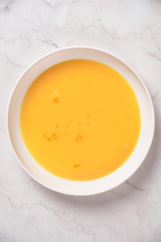 A white bowl filled with whisked egg.