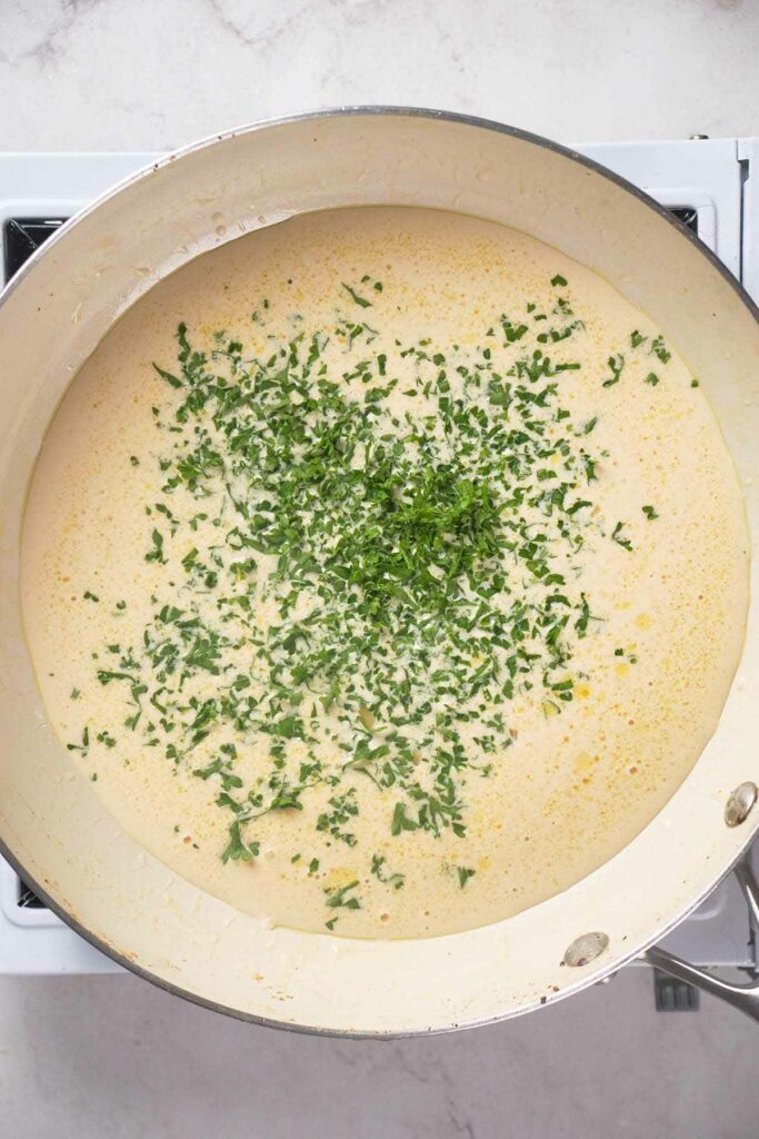 Francese sauce topped with chopped fresh green herbs.