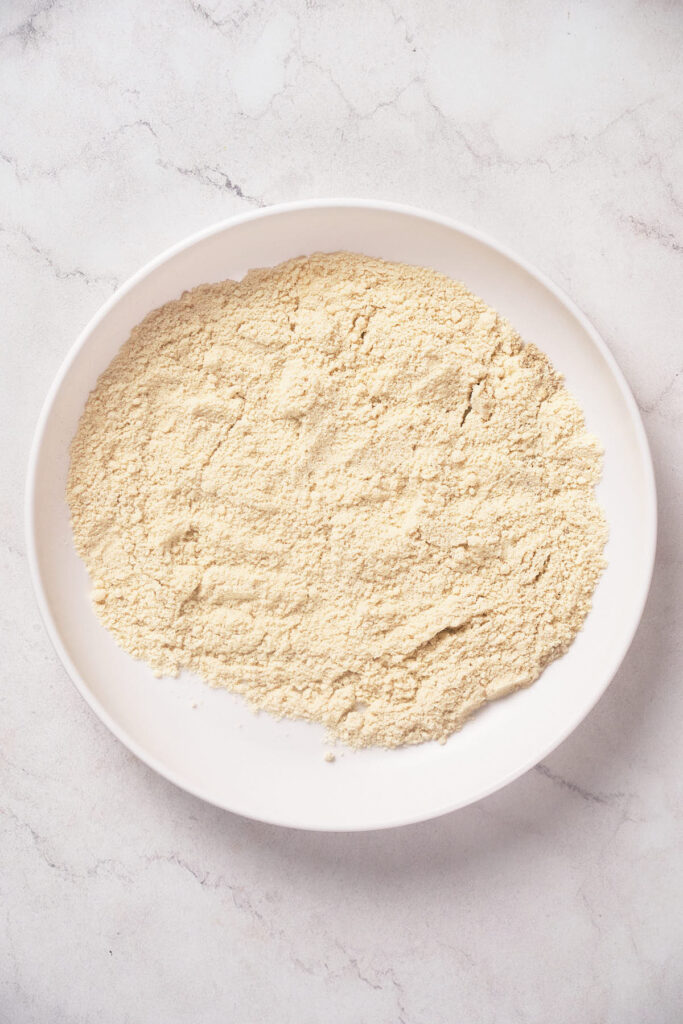 A white plate filled with flour.