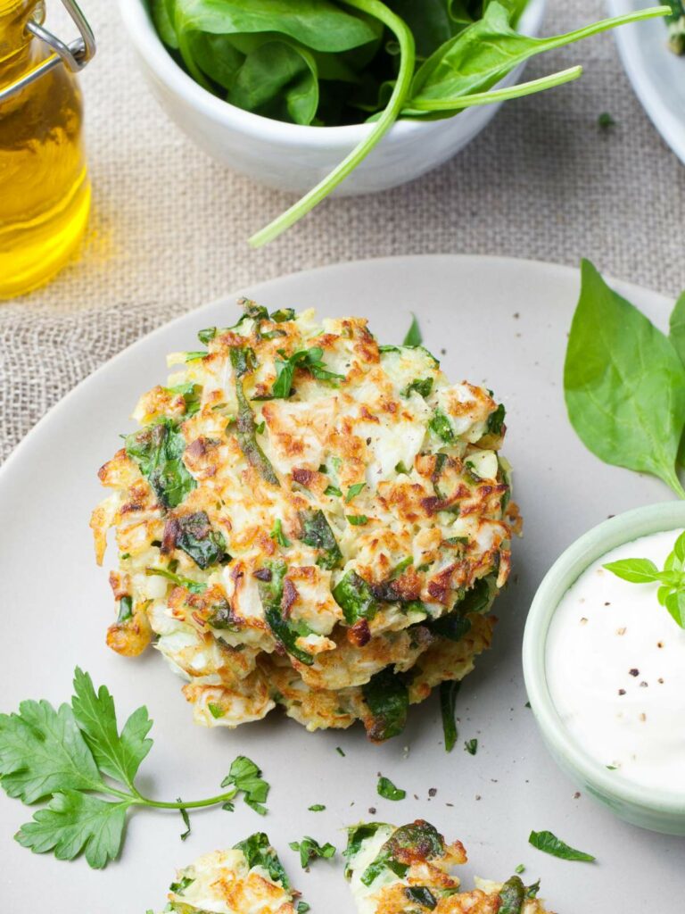Servings of cabbage fritters on a white.